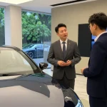 Interior showroom LUXURY 777 dengan mobil mewah dan staf yang membantu pelanggan.